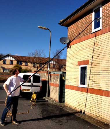 Spencer working a water fed pole beside the van