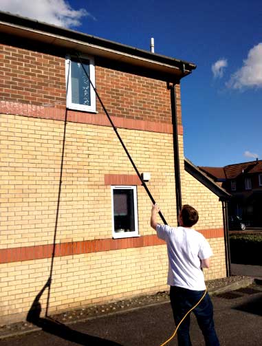 Spencer reaching a first floor window with the pole